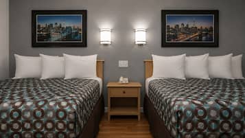 Habitación de hotel con dos camas, una mesita de noche y dos lámparas de pared.