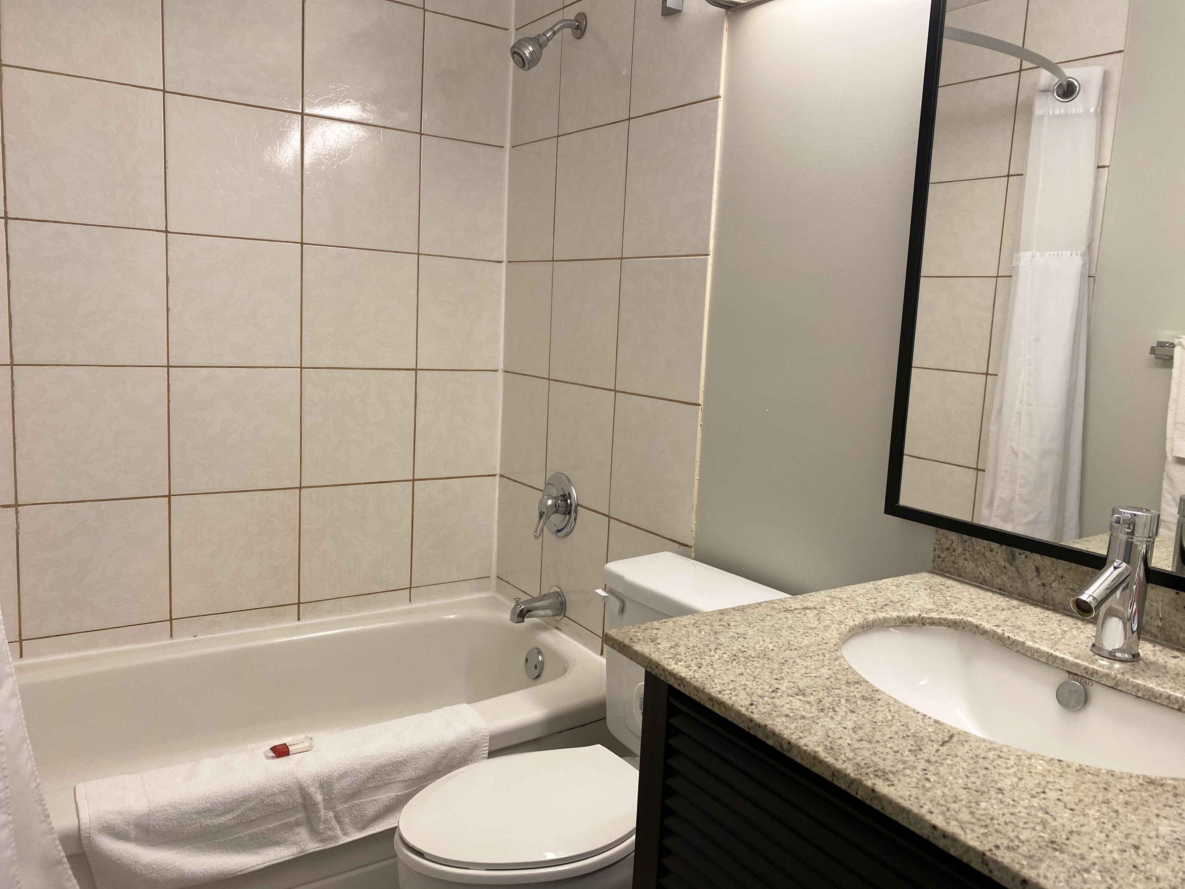 Un baño con bañera, inodoro, lavabo y espejo.