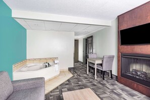 A modern bathroom with a bathtub, a sink, and a shower. There is a dining area with a table and chairs. - Travelodge by Wyndham Miramichi New Brunswick (Miramichi)