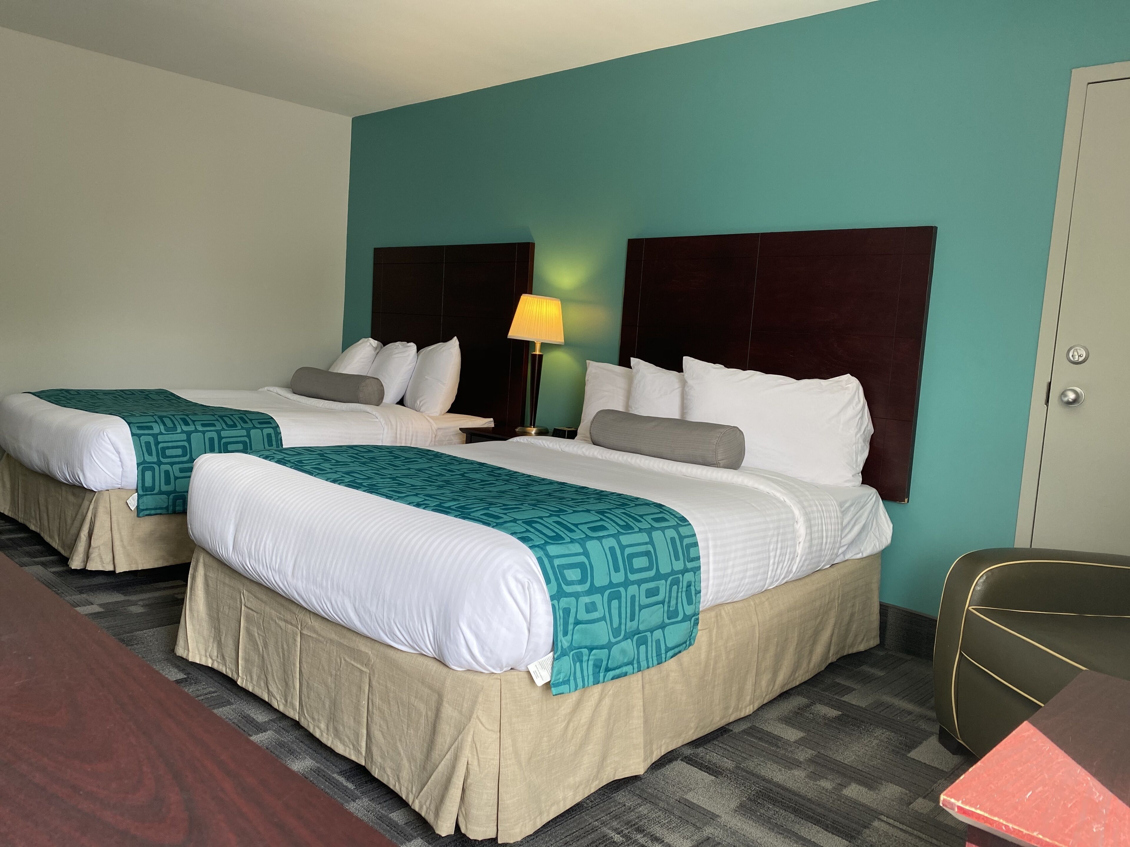 Une chambre d’hôtel avec deux lits, un bureau et une chaise.
