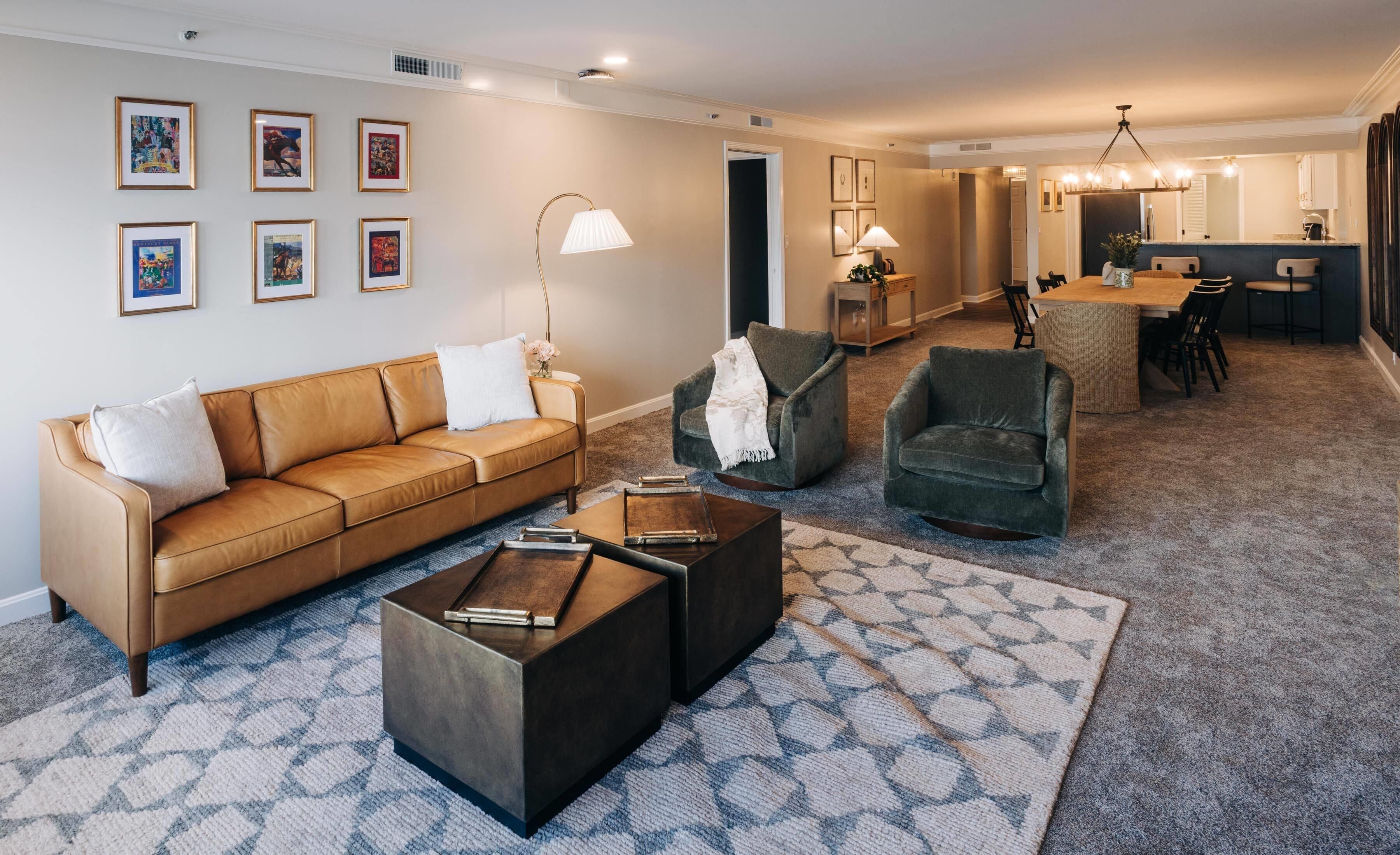 Un salon moderne comprenant un canapé, des fauteuils, une table basse et un coin repas avec une table et des chaises.