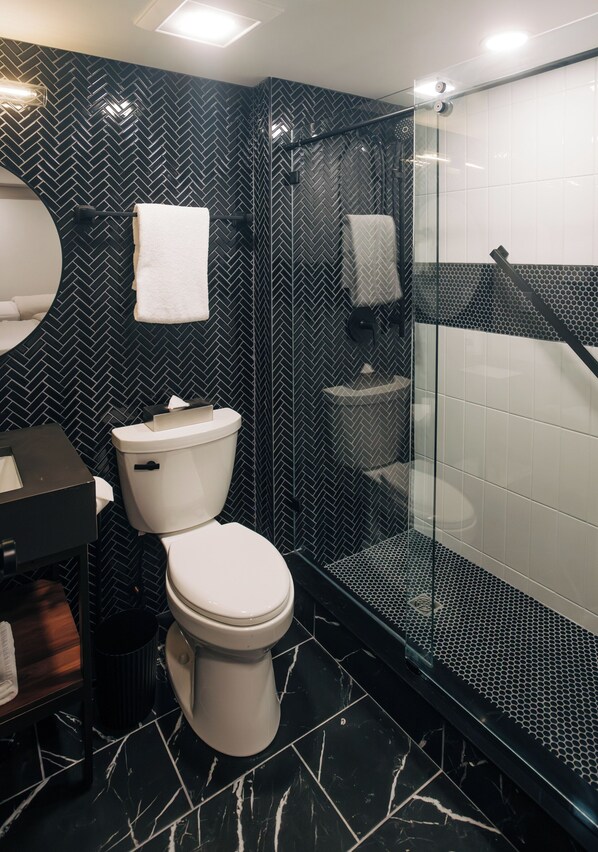 Un baño moderno con inodoro, lavabo y zona de ducha.