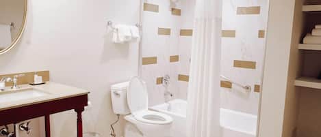 A bathroom with a toilet, sink, and shower.