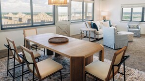 A spacious room with a large dining table, comfortable seating, a sofa, and a view of a bridge.