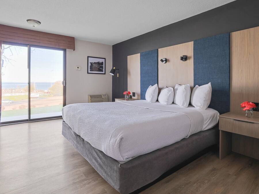 Habitación de hotel moderna con una cama grande, un escritorio y vistas al exterior.
