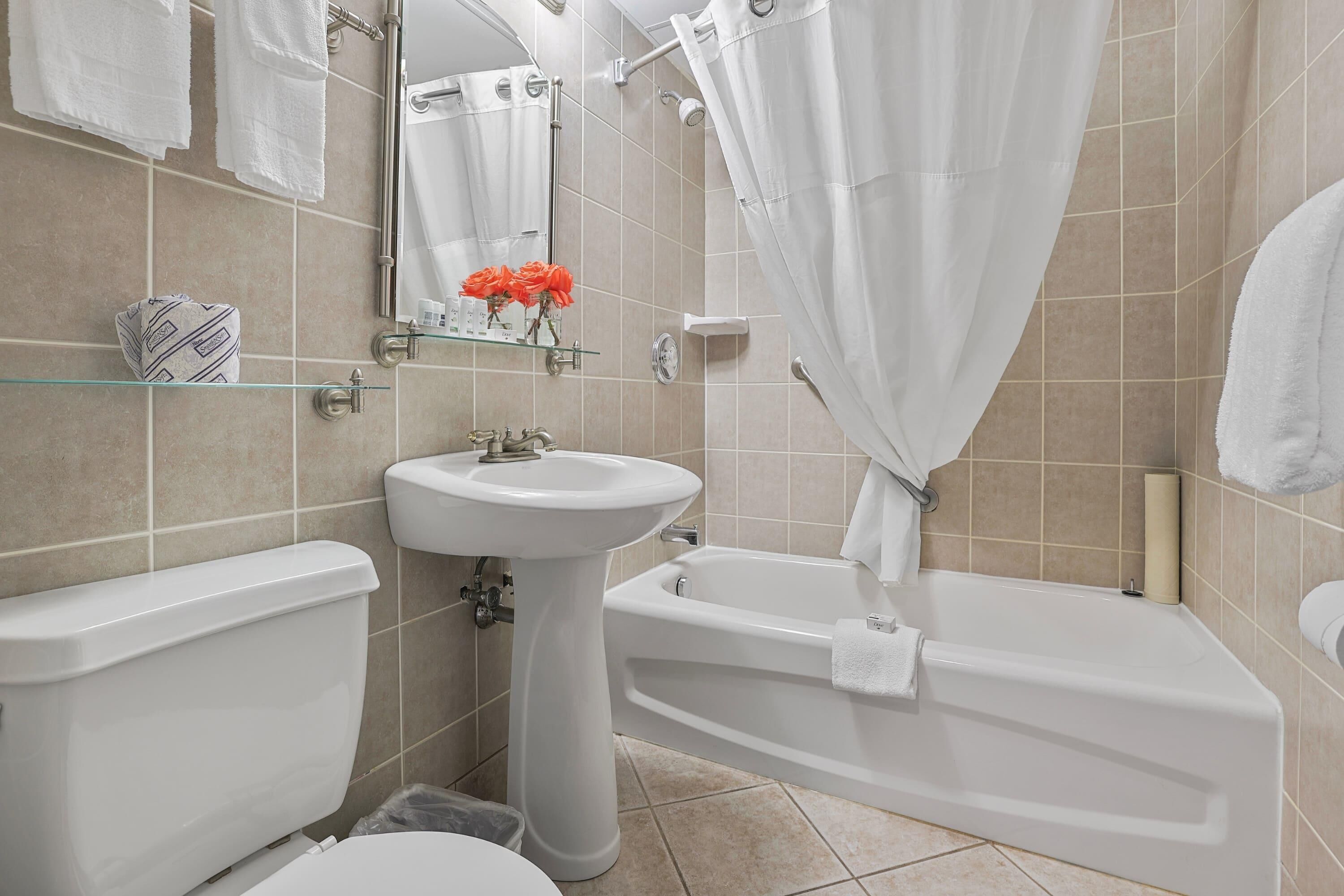 A bathroom with a toilet, sink, and bathtub.