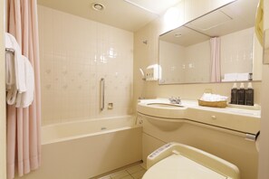 A bathroom with a bathtub, a sink, a mirror, and a toilet. - Hotel new Hankyu Osaka Annex (Osaka)