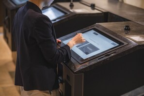 A person interacting with a digital kiosk in a modern, well-lit room with a sleek design. - Hotel new Hankyu Osaka Annex (Osaka)