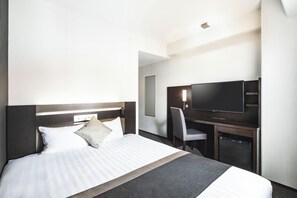 A hotel room with a large bed, a desk with a flat-screen TV, and a chair. - Hotel new Hankyu Osaka Annex (Osaka)