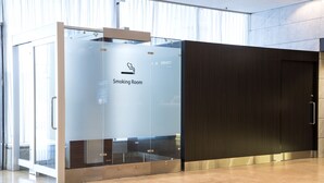 A smoking room with a glass partition, a dark wooden door, and a tiled floor. - Hotel new Hankyu Osaka Annex (Osaka)