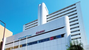 A modern hotel with a prominent 'DD HOUSE' sign, multiple floors, and a cylindrical structure on the roof. - Hotel new Hankyu Osaka Annex (Osaka)
