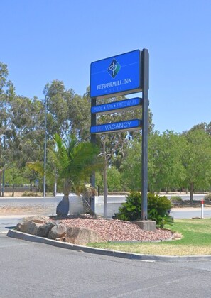 A sign for Peppermill Inn with amenities including a pool, spa, and free Wi-Fi.