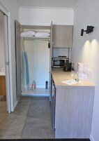Una cocina compacta con microondas, una pequeña encimera y un armario.