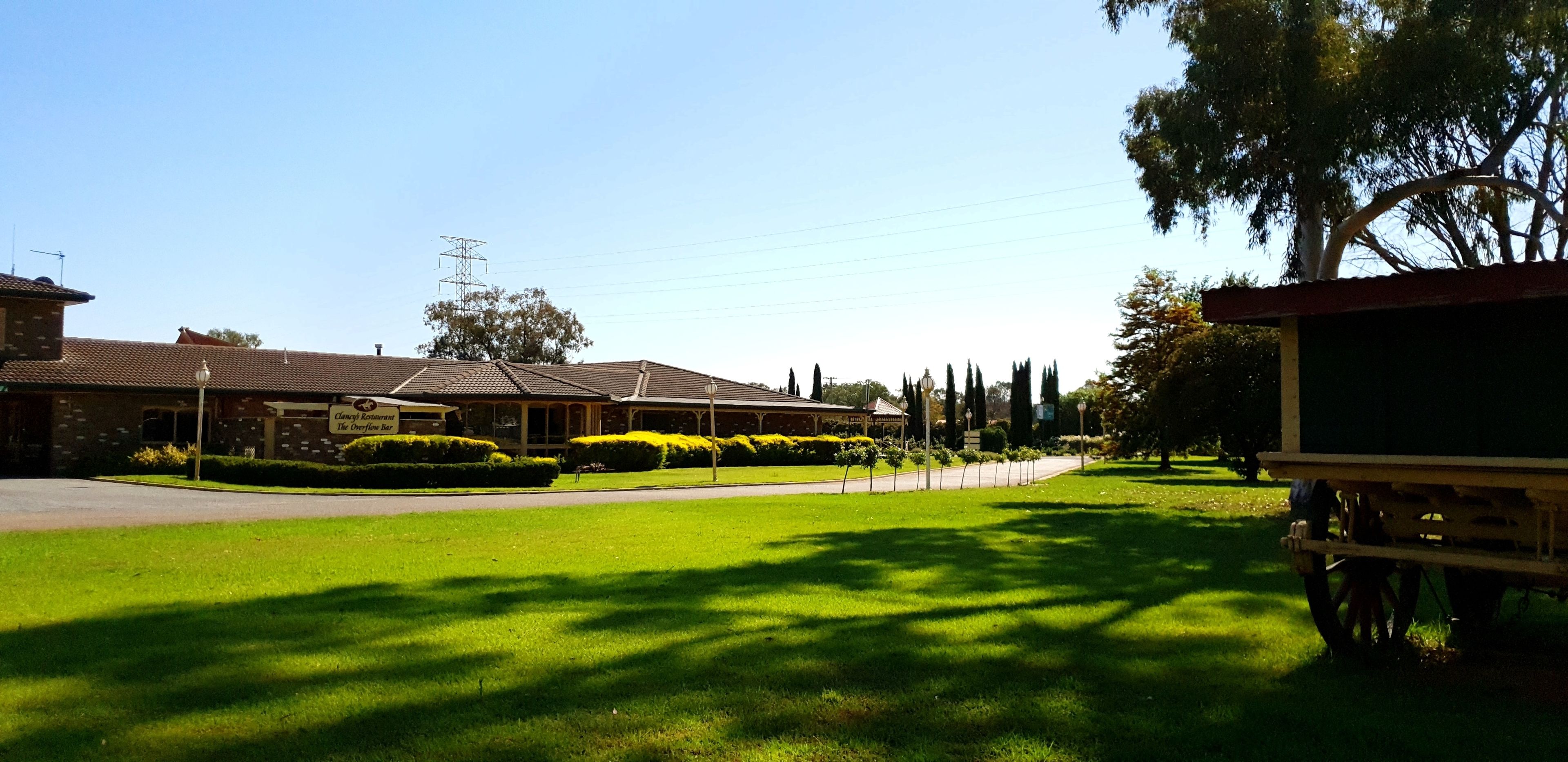 A well-maintained lawn with a paved pathway leading to a building with a tiled roof.