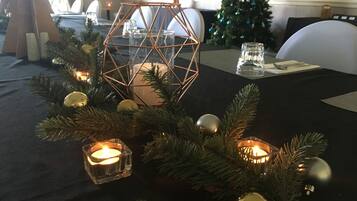 Una mesa vestida con mantel negro, velas y adornos navideños.