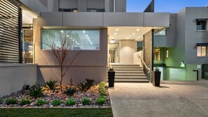 A modern building with a large glass window, a staircase, and a well-maintained garden area. - Quality Hotel Wangaratta Gateway (Wangaratta)