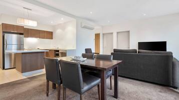 A modern apartment with a dining area, kitchen, and living space.