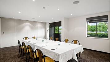 A conference room with a long table, chairs, and a large window.