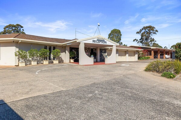 A building with a reception area, a covered entrance, and a parking lot. - Comfort Inn Glenfield (Kearneys Spring)