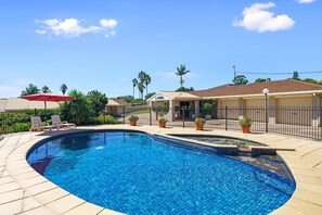 A swimming pool with a reception area, surrounded by a fence and potted plants. - Comfort Inn Glenfield (Kearneys Spring)