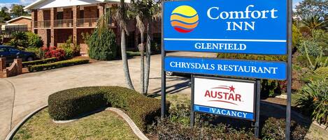 Señal de Comfort Inn con la señalización de Glensfield y Chrysdals Restaurant debajo.