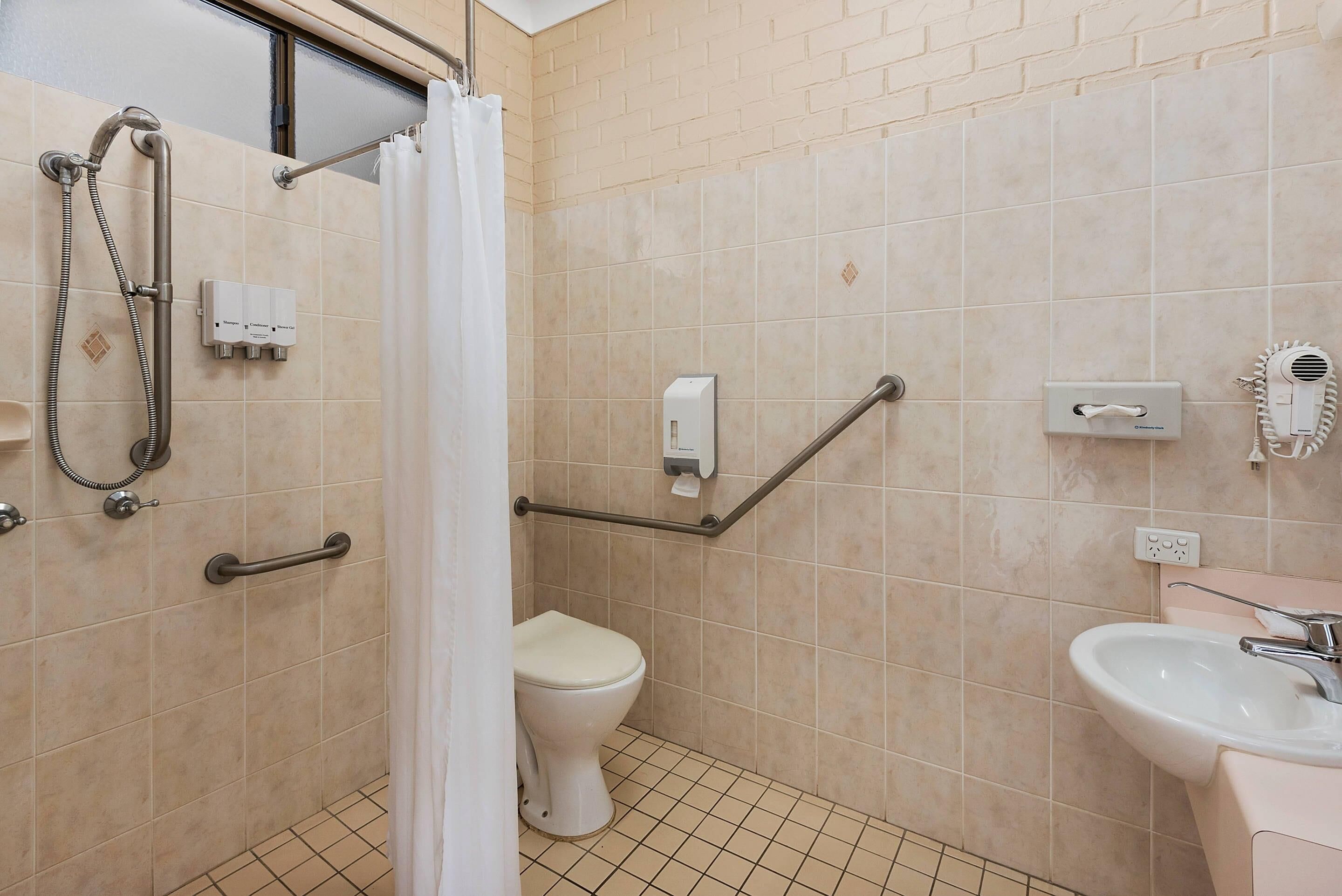 A bathroom with a shower, toilet, and sink.