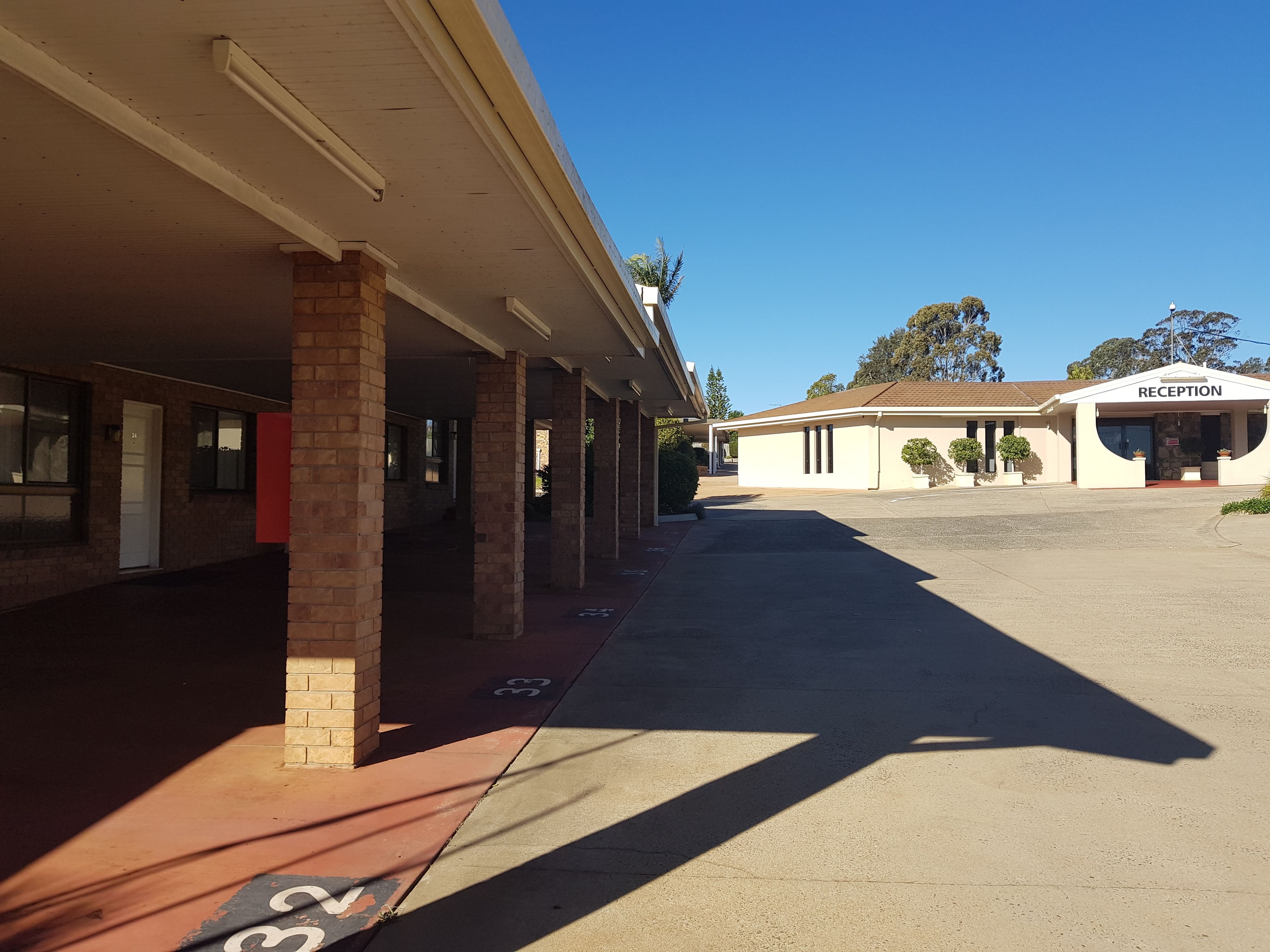A building with a reception area, covered outdoor seating, and a brick facade.