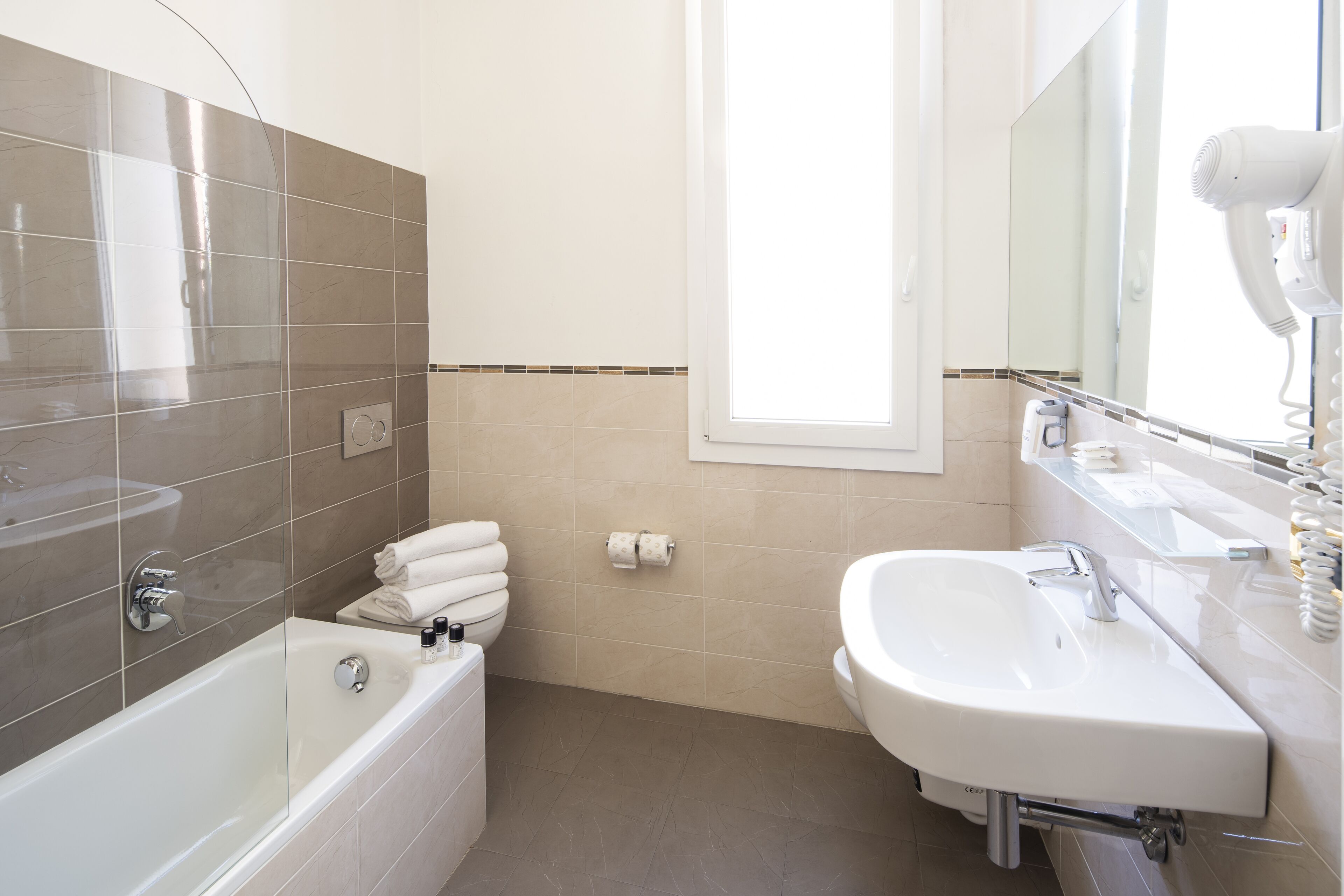 A modern bathroom with a bathtub, a sink, and a mirror.
