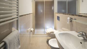 Un bagno moderno con doccia vetrata, lavandino bianco e WC.