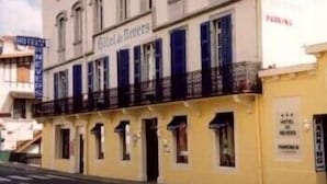 A hotel with a sign reading "Hotel des fleurs" and a visible entrance.