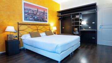 Un dormitorio con una cama, dos mesitas de noche con lámparas, un cuadro de un paisaje urbano en la pared y un armario con espejo.
