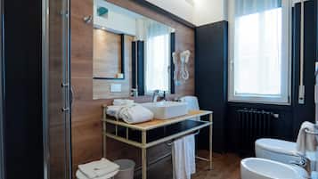 A modern bathroom with a wooden vanity, a large mirror, a shower, and a toilet.