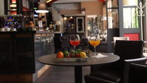 A dining area with a round table, two drinks, and a fruit platter. - Hotel Italia (Verona)