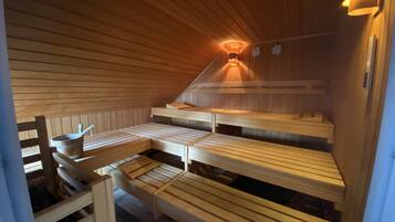 A sauna with wooden benches and a sloped ceiling.