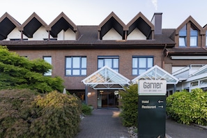 A hotel entrance with a sign indicating directions to the hotel and restaurant. - Hotel Elisenhof (Moenchengladbach)