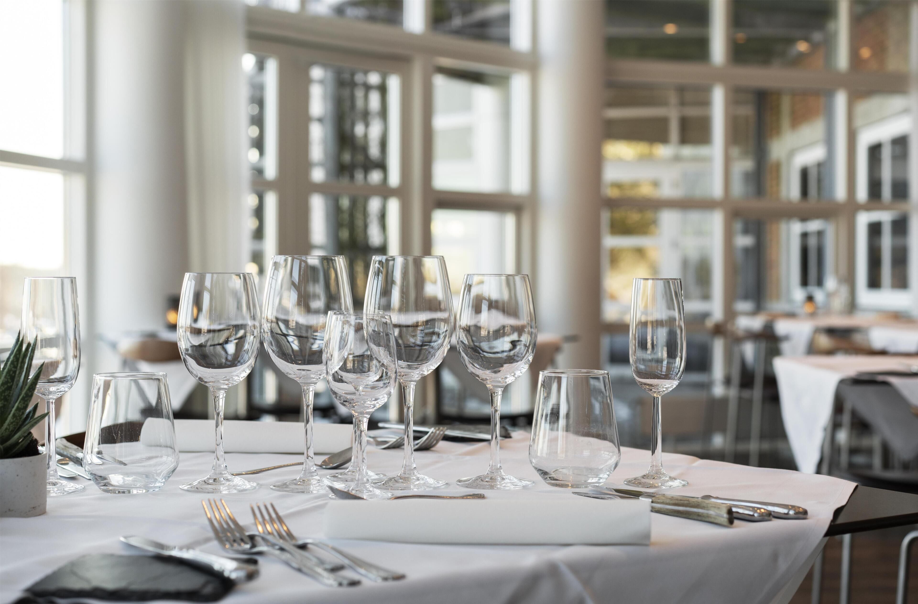 A table set with multiple wine glasses and cutlery, indicating a formal dining setting.