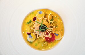 A dish with a yellow sauce, garnished with green herbs and red elements. - Zur Weinsteige (Stuttgart)
