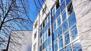Ένα σύγχρονο κτίριο με μεγάλα παράθυρα και μια πινακίδα που υποδεικνύει ότι πρόκειται για ξενοδοχείο.