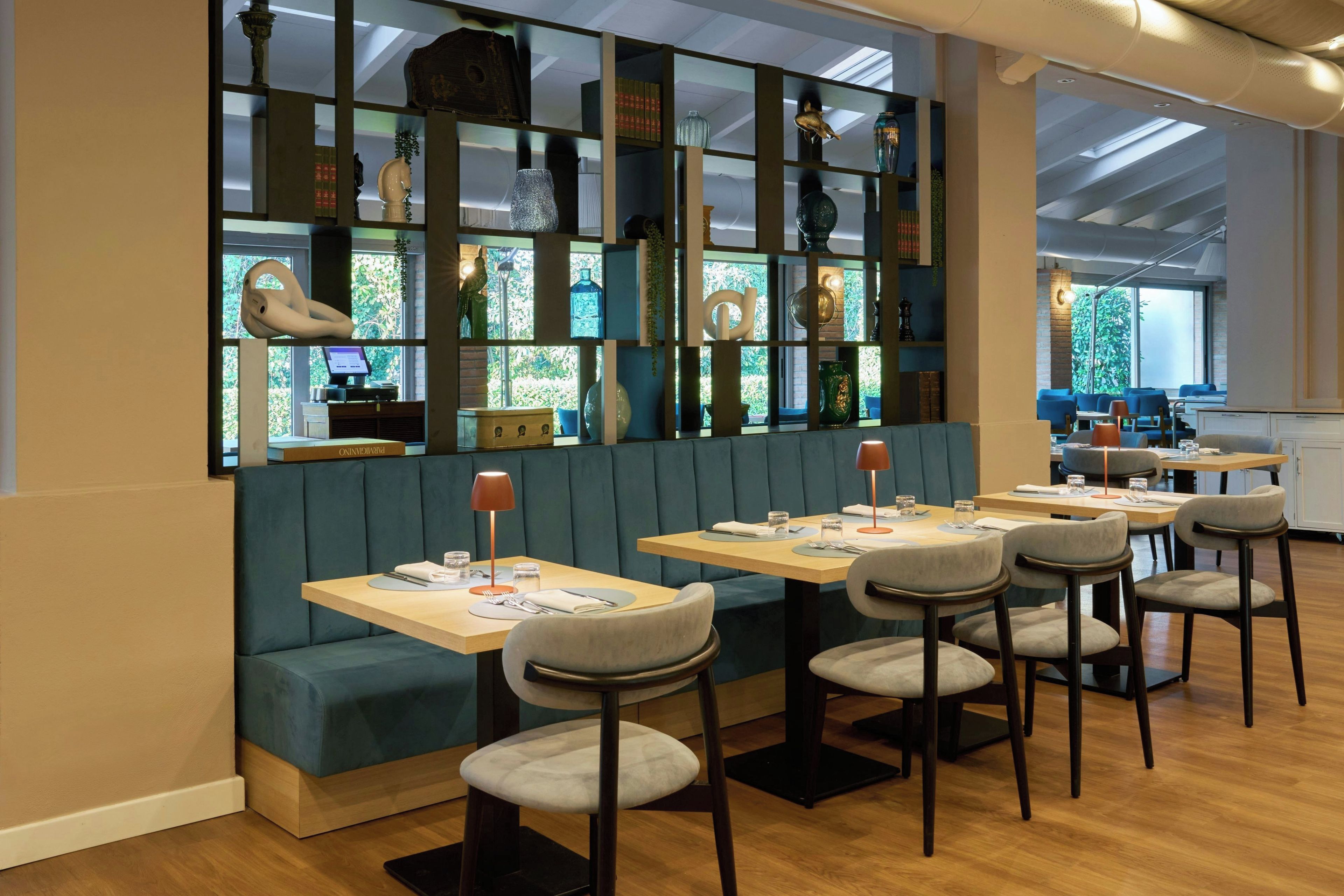 A restaurant with booths and tables, a wooden floor, and a view of the outdoors.