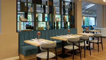 A restaurant with booths and tables, a wooden floor, and a view of the outdoors.