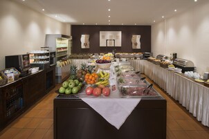 A buffet with various fruits, vegetables, and prepared foods.