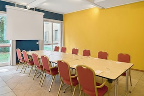 A conference room with a large table, red chairs, and a whiteboard. - Four Points Flex by Sheraton Parma (Parma)