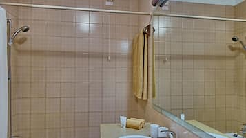 A bathroom with a bathtub, a sink, and a mirror.