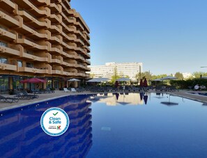 Een buitenzwembad en ligstoelen