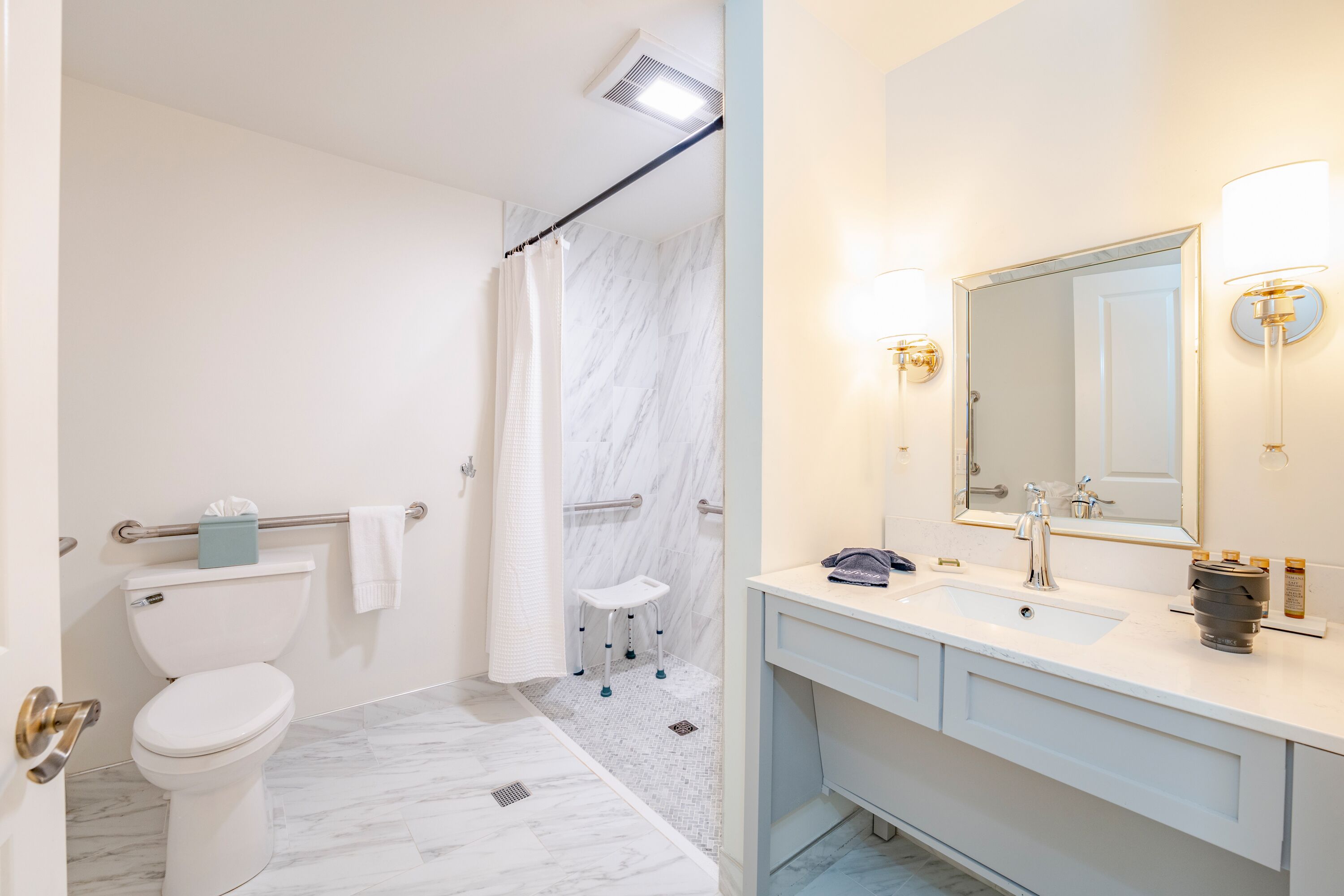 A modern bathroom with a toilet, shower, and sink.