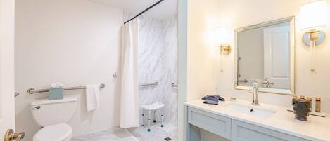 A modern bathroom with a toilet, shower, and sink.