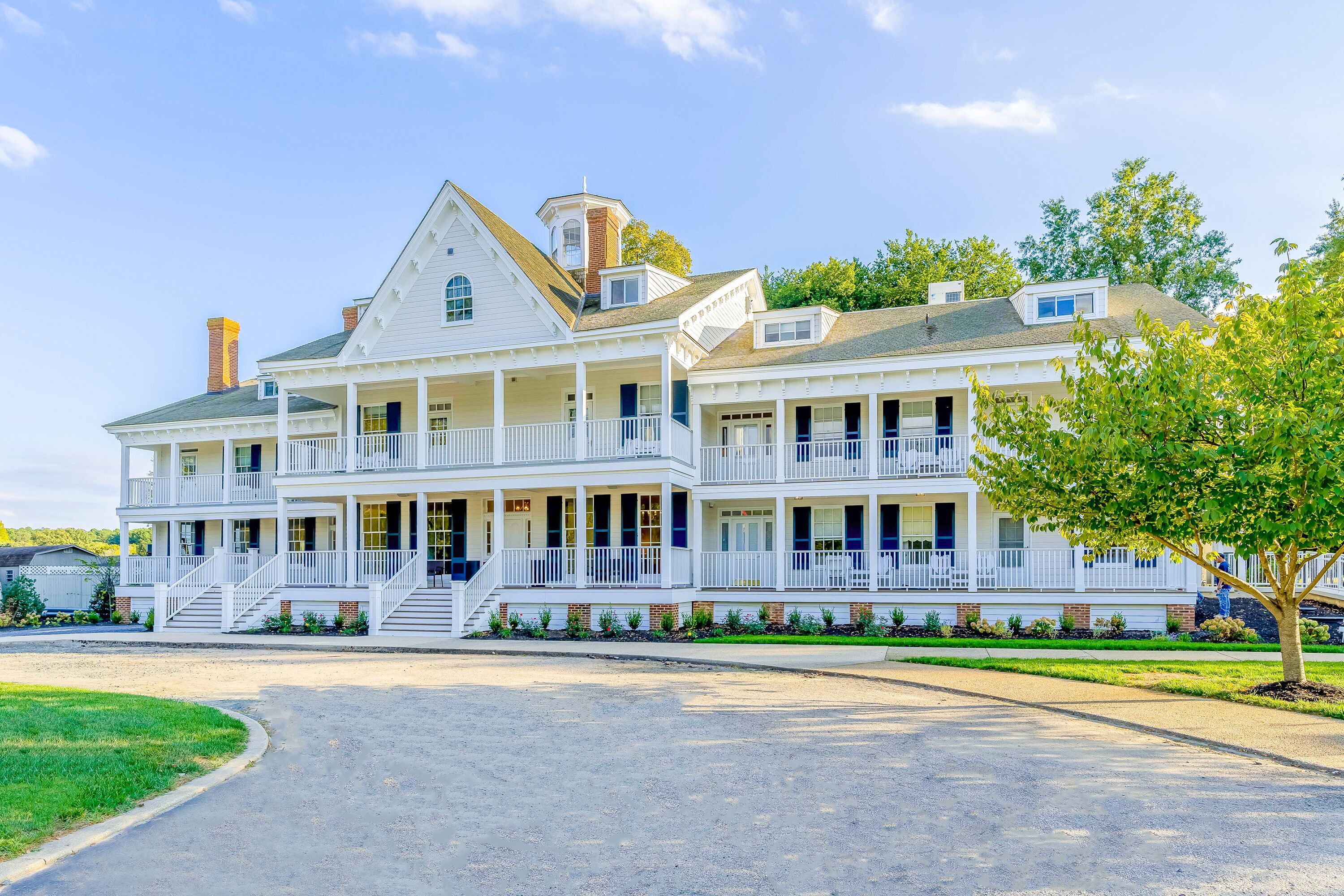A large, two-story house with a wrap-around porch and multiple windows.