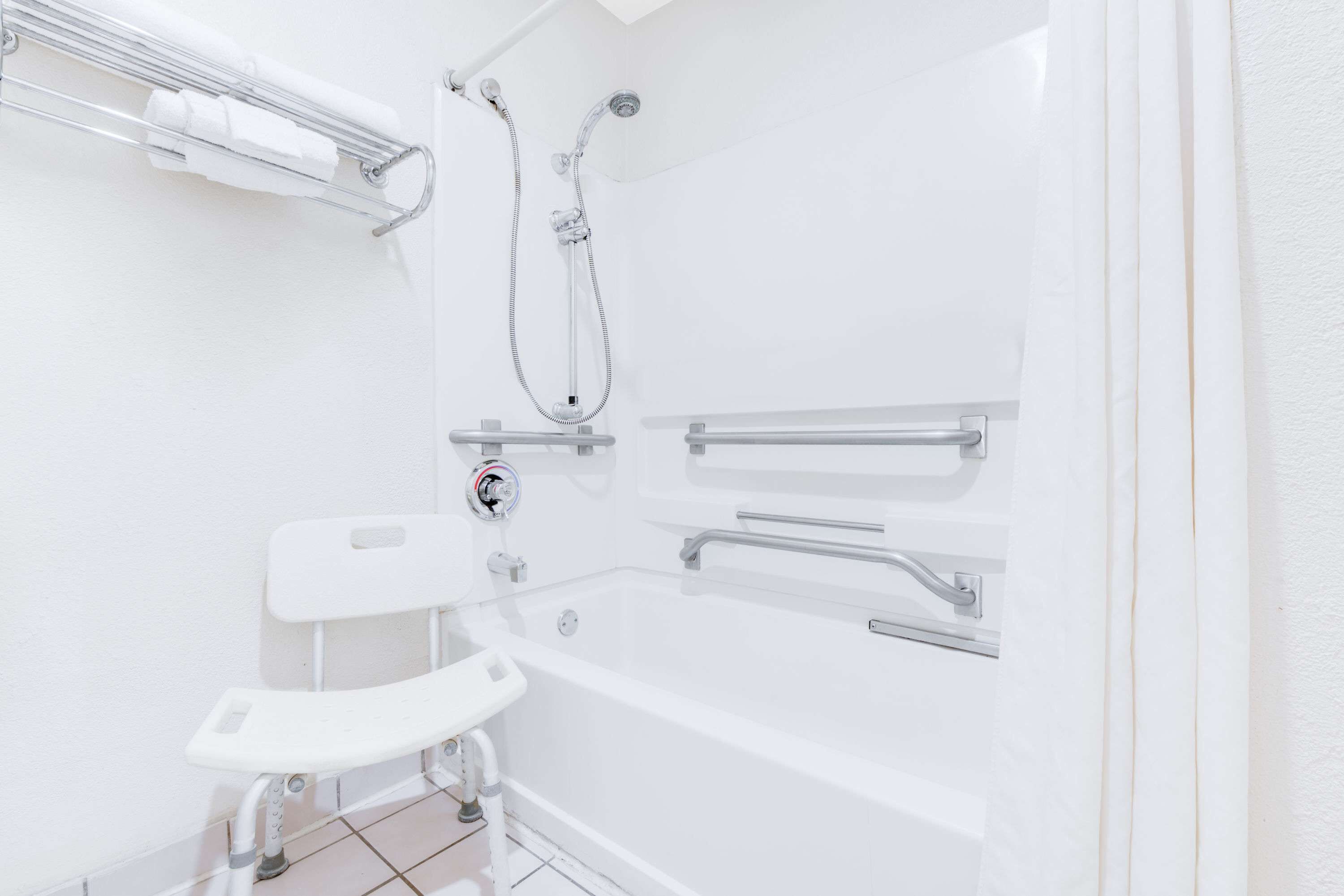 A modern bathroom with a bathtub, a shower, and a toilet.