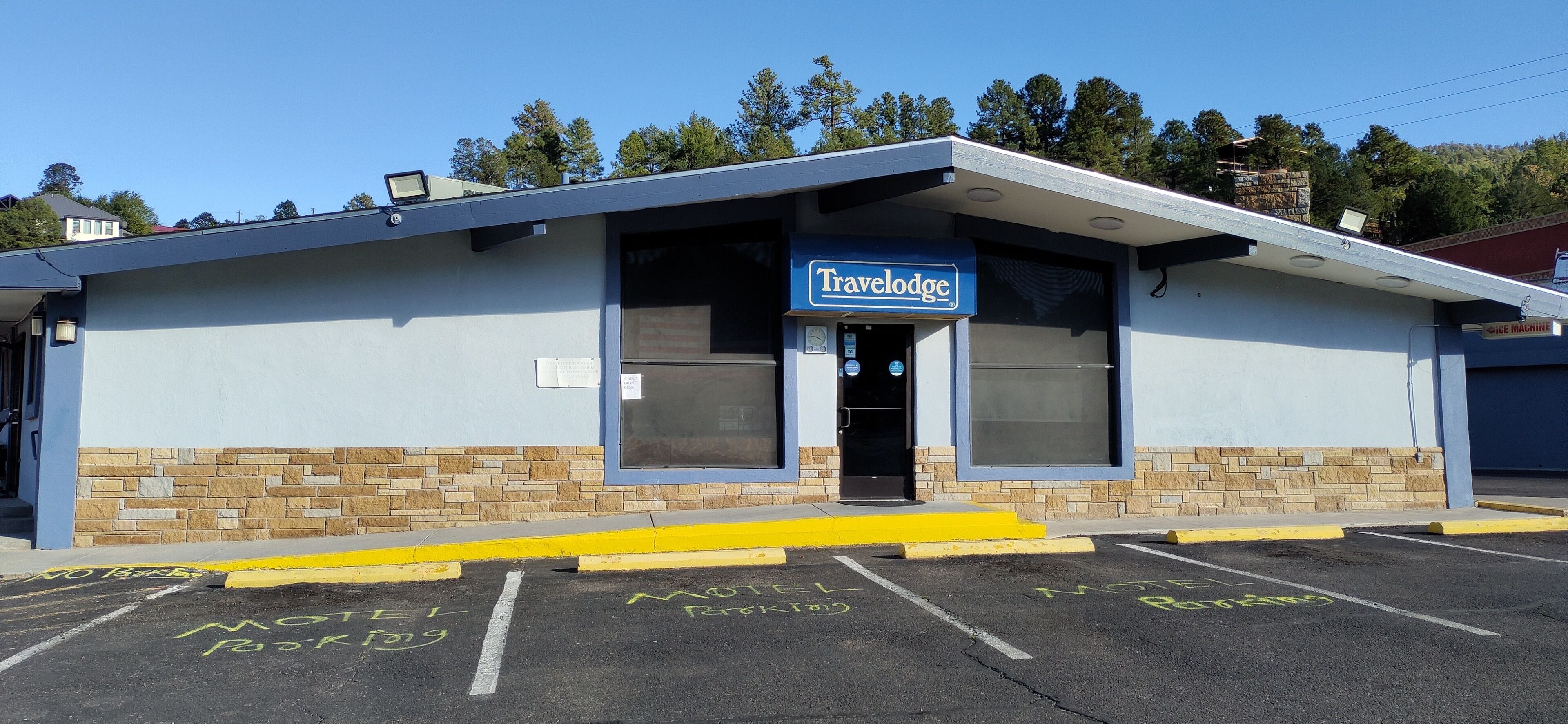 A Travelodge motel with a stone facade and a blue sign.