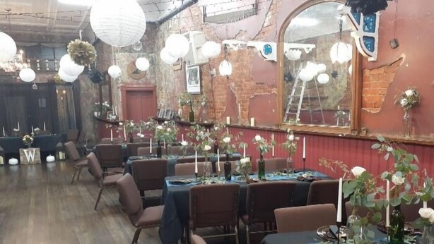 Restaurante com mesas preparadas para refeições, com velas brancas e arranjos florais.